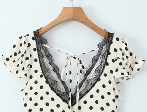 Détail du col en V avec dentelle et motif à pois sur cette blouse vintage