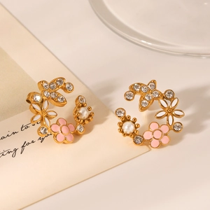 Détail des boucles d'oreilles fleurs en or 18K avec émail, perles et zircons