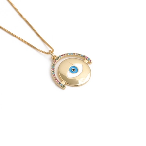 Collana con ciondolo malocchio dorato e cristalli colorati su sfondo bianco professionale