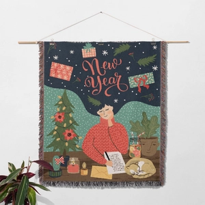 Detail of Christmas tree woven throw blanket with New Year art and fringe edges