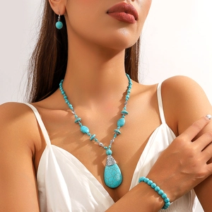 Macro shot of bohemian turquoise jewelry set with water-drop pendant on model