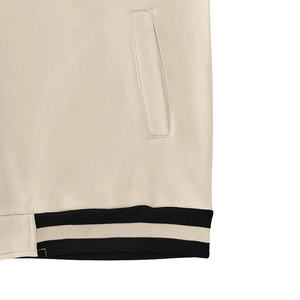 Detailed close-up of beige cardigan pocket and ribbed hem stitching with premium fabric texture
