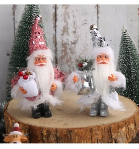 Close-up of pink and white Santa dolls with sequins and faux fur on rustic wooden logs