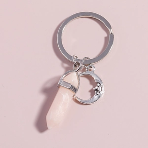 Detail of pink hexagonal crystal column and silver moon pendant on a minimalist keychain