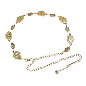 Vintage gold metal chain belt with engraved oval sunburst patterns on a white backdrop