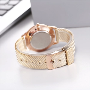 Macro detail of rose gold mesh watch band with intricate woven structure and buckle