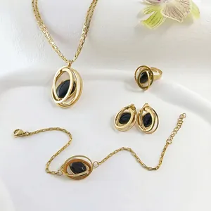 Elegant gold jewelry set with black cat-eye stones including necklace, bracelet, earrings and ring