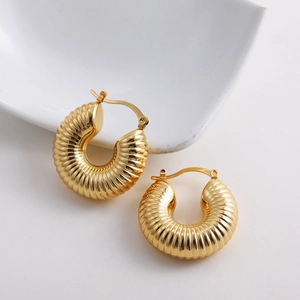 Detailed macro view of 18K gold chunky hollow hoop earrings with textured striped finish