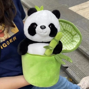 Close-up of a plush panda toy held inside a green bamboo shoot zip-up plush case