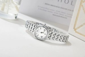 Detail of silver quartz watch with oval Roman numeral dial and rhinestone bezel