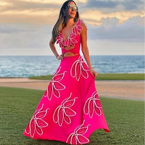 Détail des fleurs 3D et de la découpe à la taille sur une robe de vacances rose vif