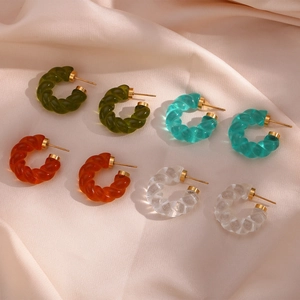 Lot de quatre boucles d'oreilles torsadées en acrylique sur un tissu en soie champagne