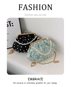 Detail of beaded shell bags in black and light green with pearl accents and gold chains