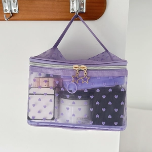 Detail of purple mesh makeup bag with flocked hearts and golden star zippers