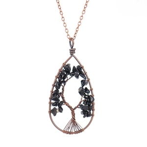Detail of copper wire-wrapped tree of life pendant with black natural stone chips