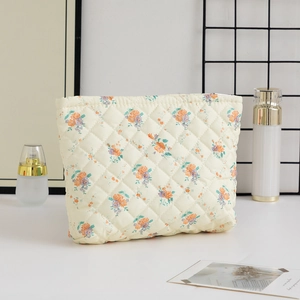 Close-up of quilted floral cosmetic bag featuring a secure top metal zipper closure