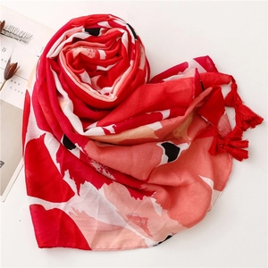 Detailed view of bohemian red floral scarf with elegant fringe and abstract patterns