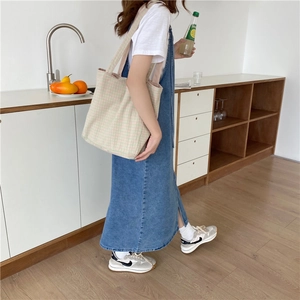 Detalle de bolso tote de lona a cuadros rosas con vestido vaquero para estilo informal