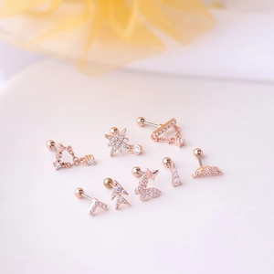 Set of 8 rose gold stainless steel screw-back stud earrings with zircon inlays on pink background