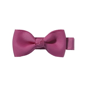 Detail of purple grosgrain ribbon hair bow with textured surface and metal clip