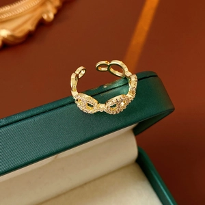 Detailed view of a gold-plated bow-shaped open ring with sparkling pavé-set zirconias