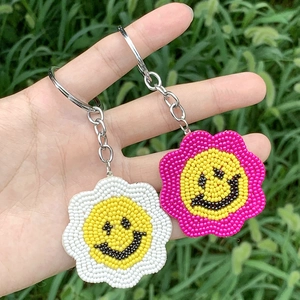 Close-up of handmade daisy bead keychains with smiling flower charms for bag decor