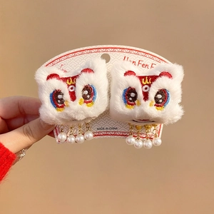 Detail of lion dance hair clips with white plush, embroidery, and pearl tassels