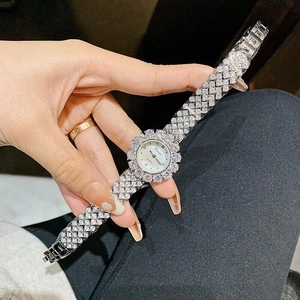 Close-up of luxury silver quartz watch for women with full rhinestones and white dial