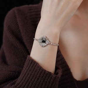 Detail of silver flower bracelet with black square gemstone and clear rhinestones