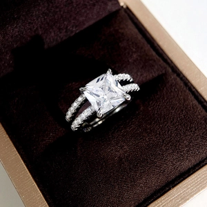 Macro view of princess cut square stone and double-row pavé band in velvet box