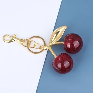 Detail of red glitter cherry keychain with gold metal leaves and snap hook closure