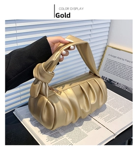 Detailed view of the gold ruched cloud bag with knotted handle and metallic PU texture