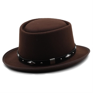 Detailed macro view of dark brown wool felt pork pie hat with studded leather belt