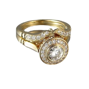 Elegant gold engagement ring set with round centerpiece and pavé diamonds on white background