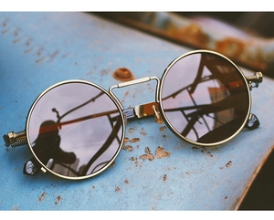 Detailed close-up of steampunk sunglasses with vintage gold metal frames and brown lenses