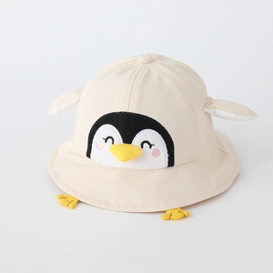 Détail du chapeau de soleil beige en coton pour enfant avec broderie pingouin et éléments 3D