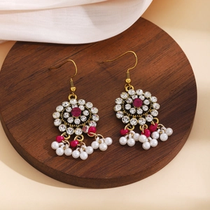 Detailed close-up of Bohemian tassel earrings with vibrant rhinestones on a wood base