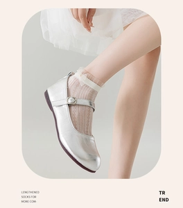 Close-up of silver Mary Jane flats paired with sweet light-colored lace floral socks