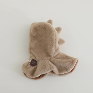 Dettaglio del cappello a dinosauro in peluche con pelliccia marrone e punte sul retro