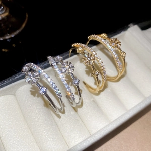 Détail des boucles d'oreilles double C fleur plaquées or 18k en or et argent