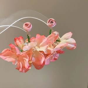 Detail of pink fabric flower earrings with green beads and crystal water drop tassels