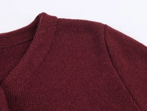 Gros plan détaillé du tissu en maille rouge bordeaux et des coutures de l'épaule