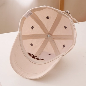 Détail intérieur de casquette en coton montrant des coutures propres et boucle en métal