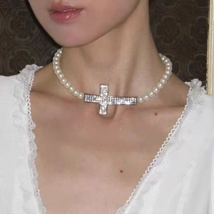 Collier de perles vintage avec grand pendentif croix en strass porté sur le cou