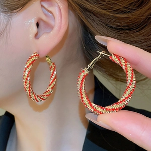 Macro view of gold hoop earrings with alternating red and white crystal rhinestones