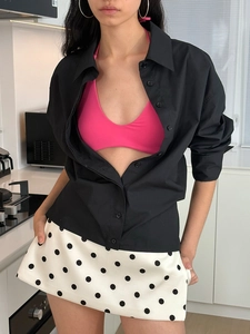 Three-piece outfit with black cardigan, hot pink crop top, and polka dot skirt set