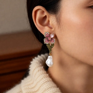 Détail de boucles d'oreilles vintage avec fleurs en cristal et perles baroques chic