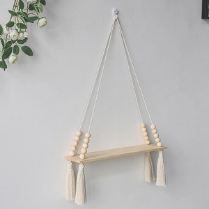 Close-up of bohemian woven cotton rope wall shelf with light wood board and beads