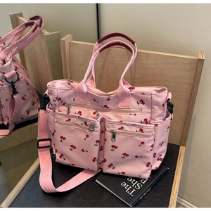 Pink tote bag with cherry print on a wooden shelf featuring multi-pocket design