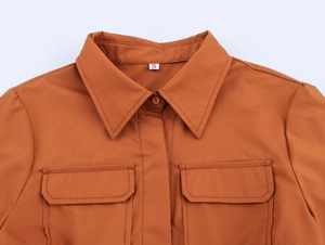 Détail de la robe chemise marron avec col à revers, poches poitrine et étiquette S